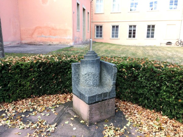 Vor dem Eingang zum früheren jüdischen Betsaal im Schwetzinger Schloss in der Zeyherstraße erinnert eine Gedenkstätte an die ehemalige jüdische Gemeinde. Der im Rahmen des Mahnmalprojektes geschaffene Vor-Ort-Stein ist Teil dieser Gedenkstätte.